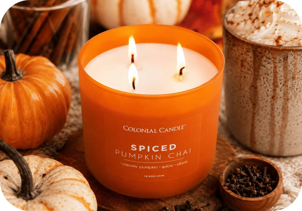Spiced Pumpkin Chai candle surrounded by pumpkins, spices, and a warm autumn drink